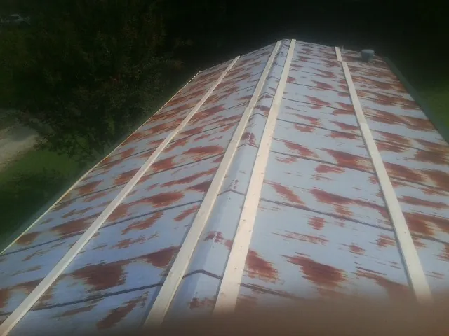 Rusted metal roof panels with new wood purlins before replacement — Storm Damage Roof Repair in Coopersville by Roofing Brothers